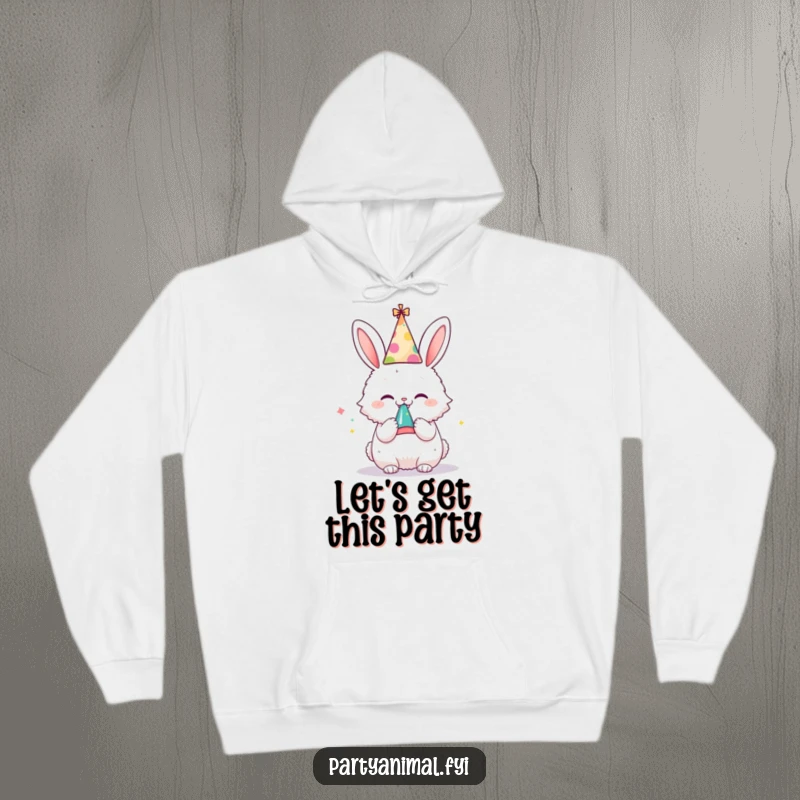 Funny hoodie with a cute bunny character in a party hat, blowing a noisemaker with infectious glee, offering cozy celebration.